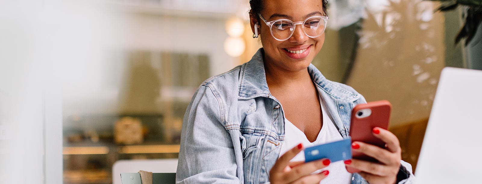 Woman looking at a credit card and phone