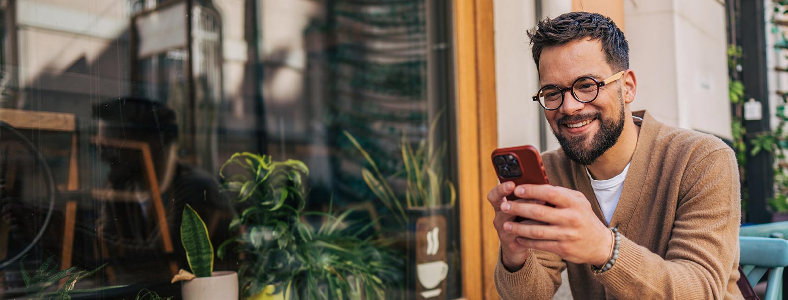 Guy with phone at a cafe